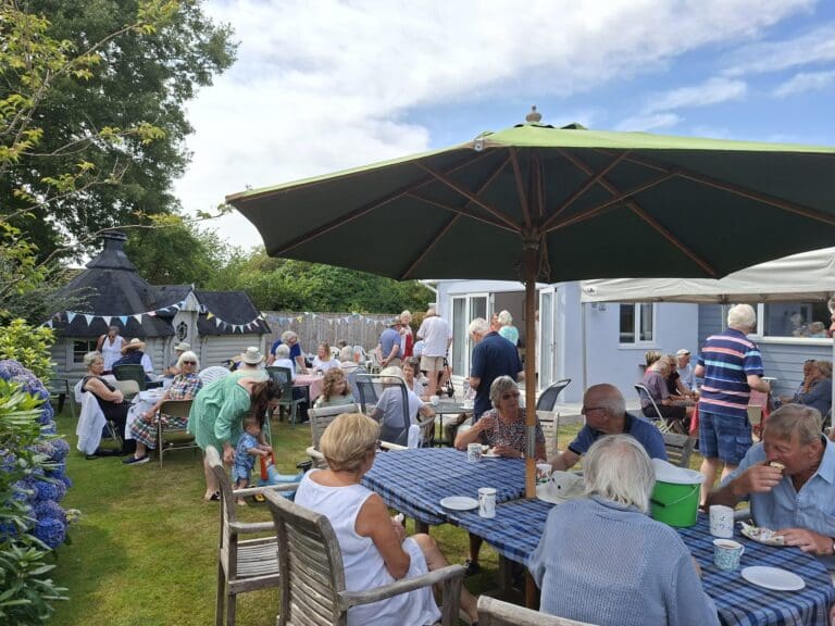 People enjoying a cream tea outside